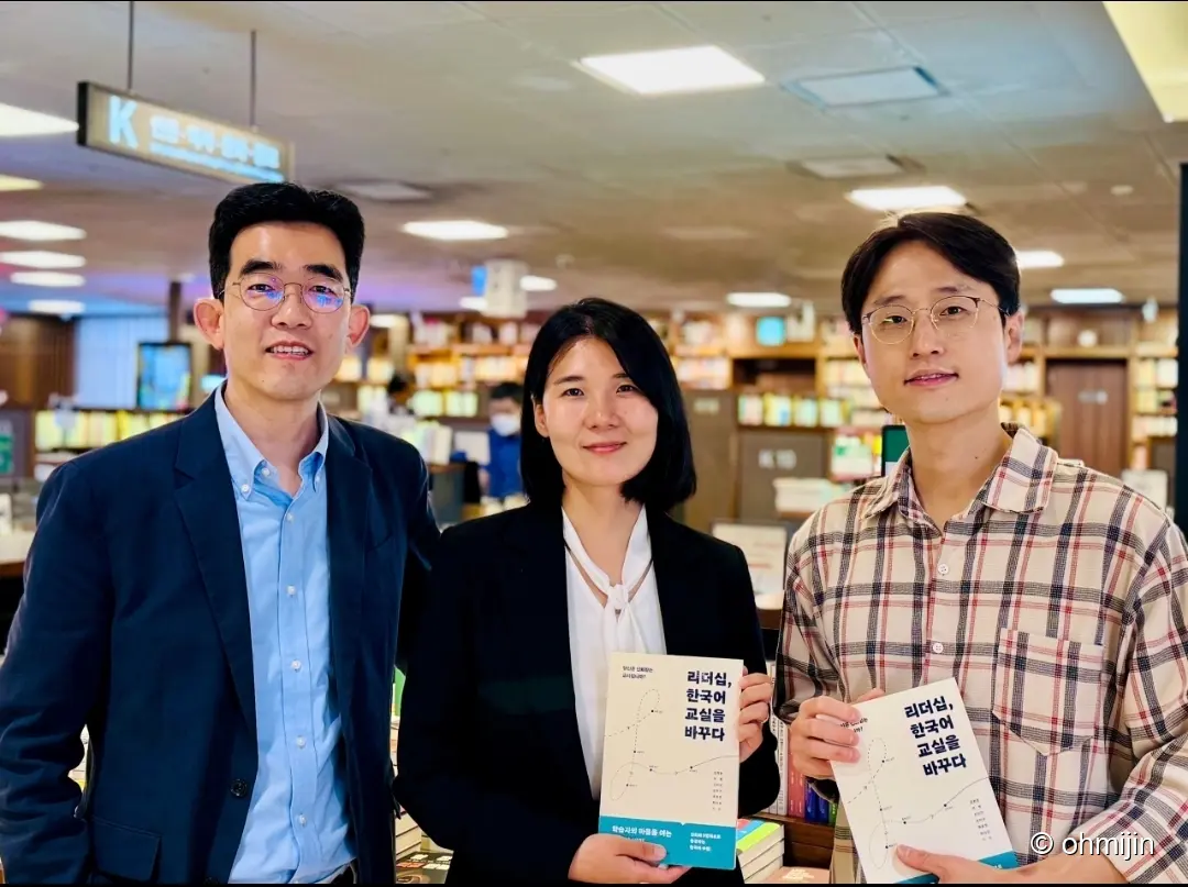 서점 책장 앞에서 리더십 한국어 교실을 바꾸다 책을 손에 들고 환하게 미소 짓고 있는 공동 저자진 단체 기념사진